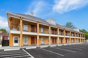 A motel with a row of rooms, a covered parking area, and a clear sky. - Quality Inn Decatur River City (Decatur)