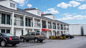 A motel with a row of rooms, a red awning, and a parking lot. - Econo Lodge Greenville near University (Greenville)