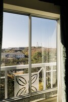 Una ventana con vistas a un edificio y árboles.