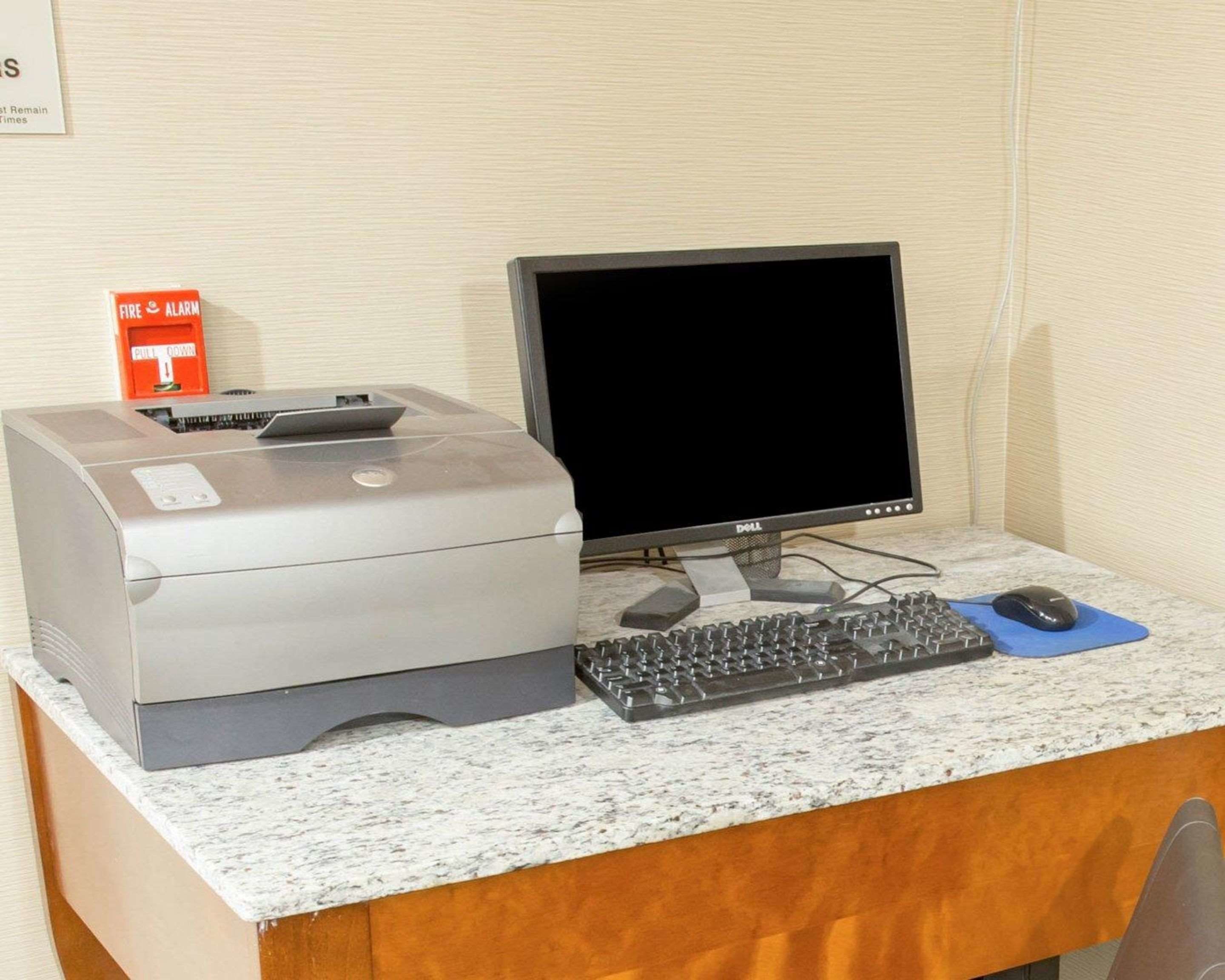 A desktop computer with a monitor, keyboard, and mouse on a marble countertop.