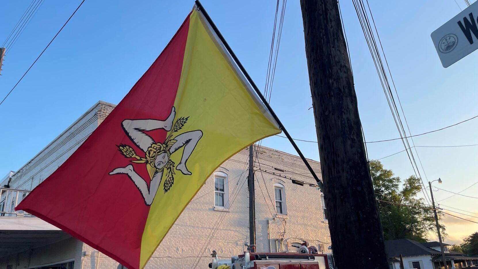 A flag with a red and yellow design, featuring a figure and wheat sheaves.