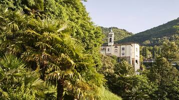 A building with a tower, surrounded by lush greenery and hills.