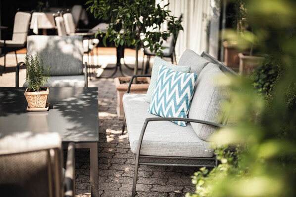An outdoor seating area with a sofa, chairs, and a small potted plant. - Hotel Belvedere Locarno (Locarno)