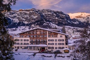 Experience the charm of a traditional Alpine hotel, set amidst a serene mountainous landscape.
