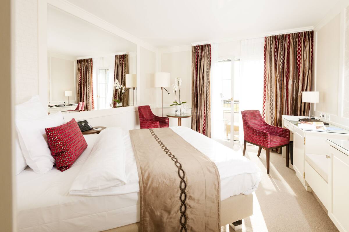 Een hotelkamer met een groot bed, een bureau, een stoel en een badkamer.
