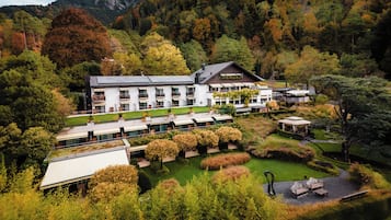 Un hotel moderno con varios pisos, asientos al aire libre y un jardín.