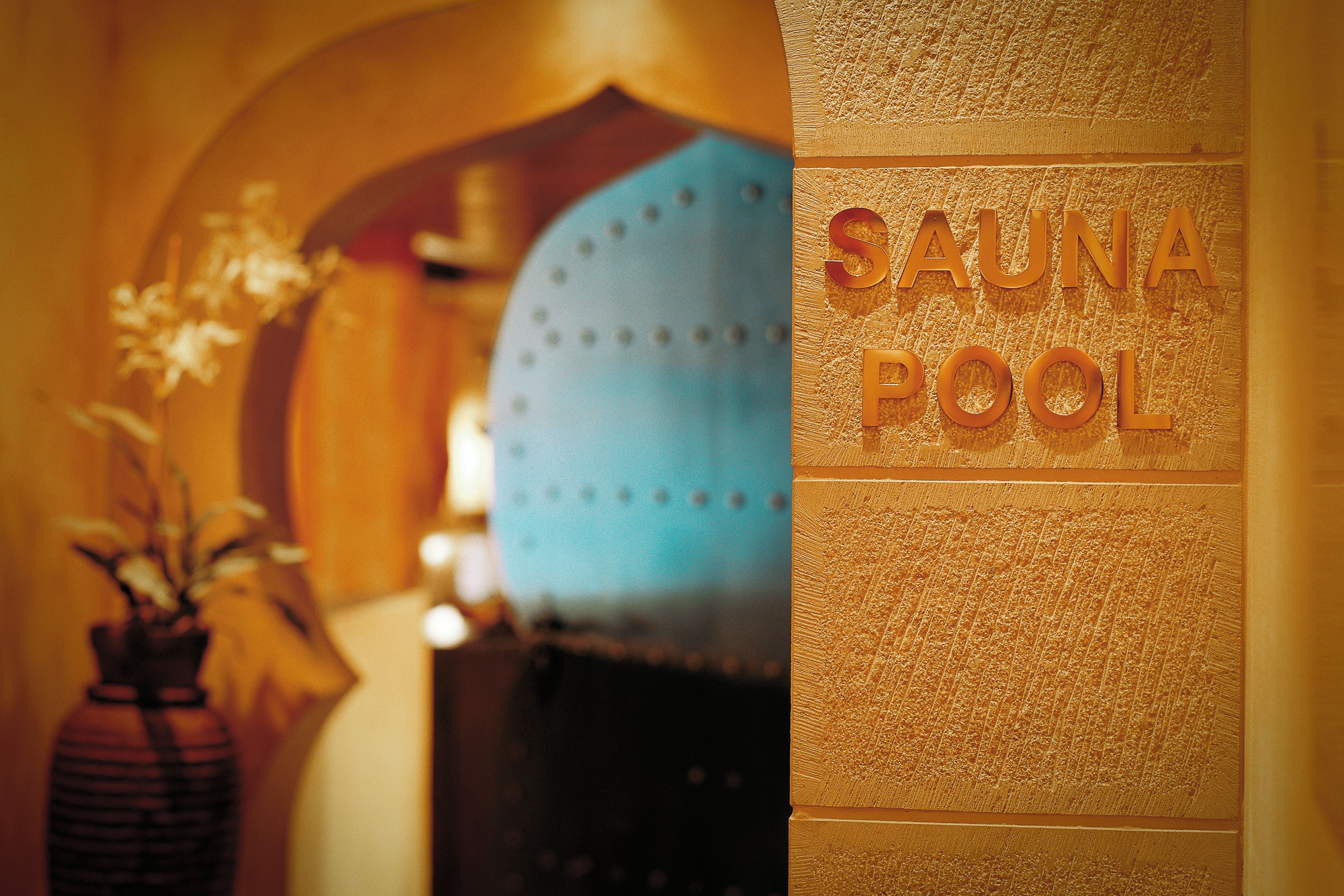 A spa area with a sign reading 'SAUNA POOL' and a blue garment hanging in the background.