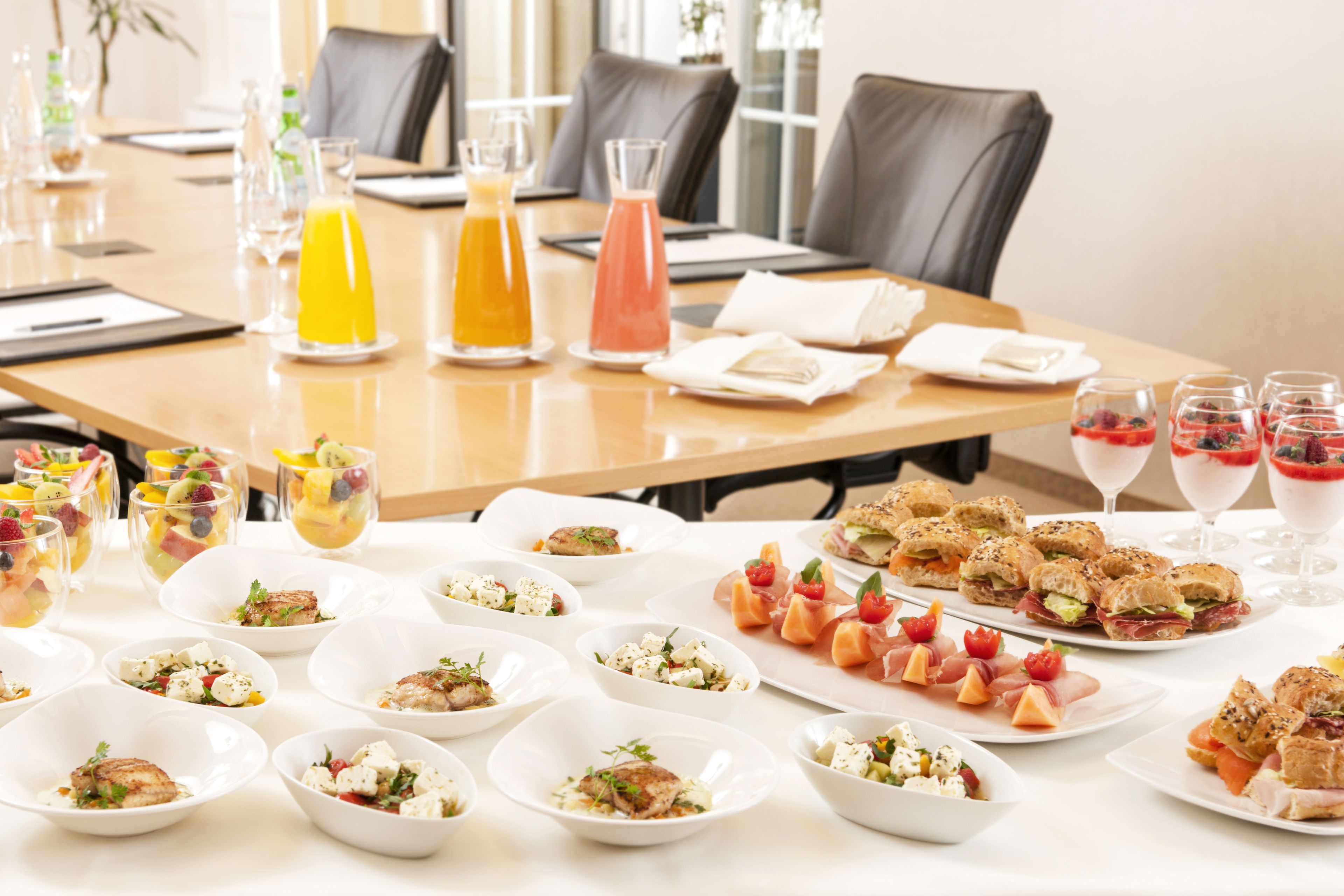 A dining table set with various dishes, drinks, and glasses.