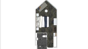 A bedroom with a bed, a bathroom with a toilet and sink, and a small sitting area with a chair and table.