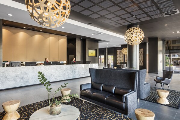 Relax in style with a comfortable sofa, flat-screen TV, and a potted plant in our inviting lobby.