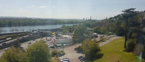 A parking lot with cars, a bridge, and a river in the background.