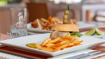 A plate of food with a sandwich, fries, and a glass of water.