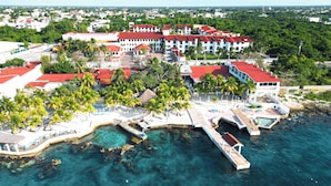 An aerial view of a resort with multiple buildings, a marina, and clear blue waters. - Cozumel Hotel & Resort (Cozumel)