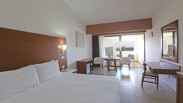 Ein Hotelzimmer mit einem großen Bett, einem Schreibtisch, einem Stuhl und einem Balkon mit Blick.