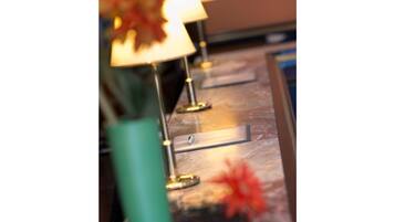 A row of lamps with a metallic base and a glass top, placed on a marble surface.