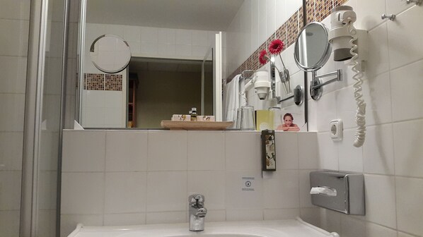 A bathroom with a sink, mirror, and a towel rack.