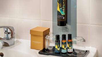 A bathroom sink with a chrome faucet, a soap dispenser, and a box labeled "ACCESSORIES SET".