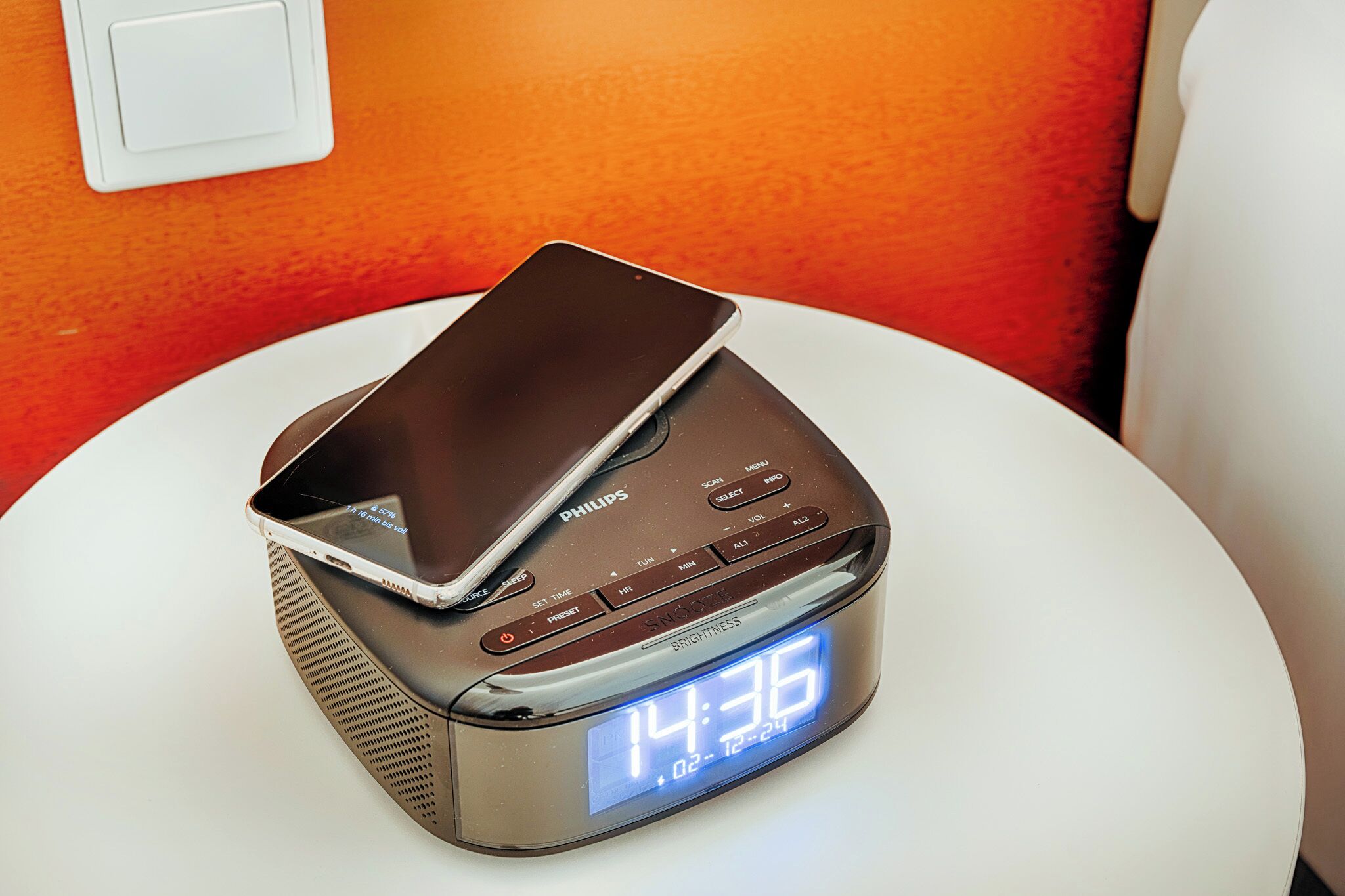 A Philips digital clock with a smartphone on top, displaying the time as 14:36.