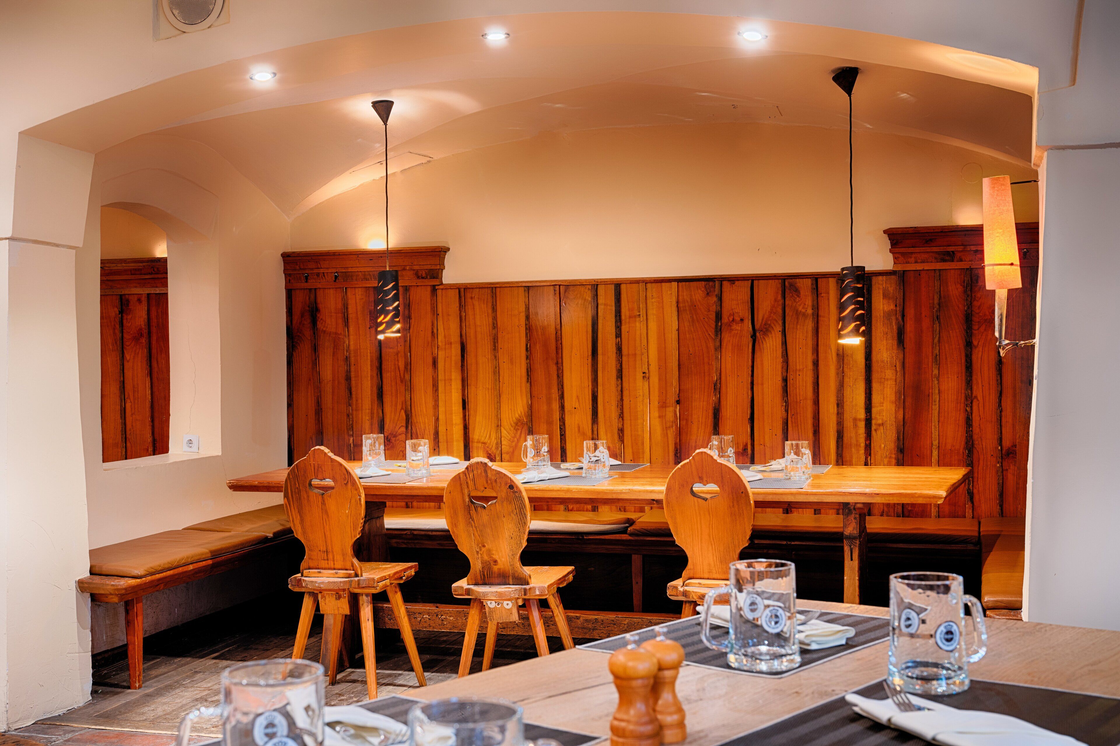 Un restaurant avec des meubles en bois et un plafond haut.