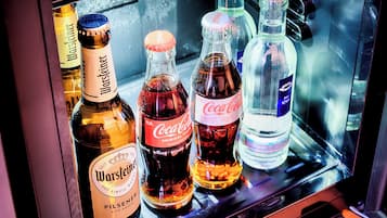 A refrigerator stocked with various beverages including Warsteiner, Coca-Cola, and other drinks.