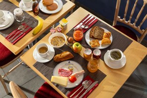 A breakfast setting with plates of food, utensils, and beverages on a table. - Hotel Queen Mary Paris (Paris)