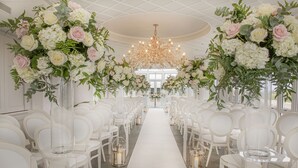 A wedding aisle with white chairs and floral arrangements on either side. - Old Course Hotel (St. Andrews)