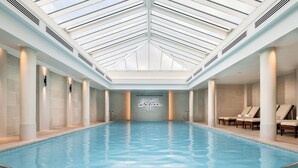 A large indoor swimming pool with a high ceiling and skylights, surrounded by columns and lounge chairs. - Old Course Hotel (St. Andrews)