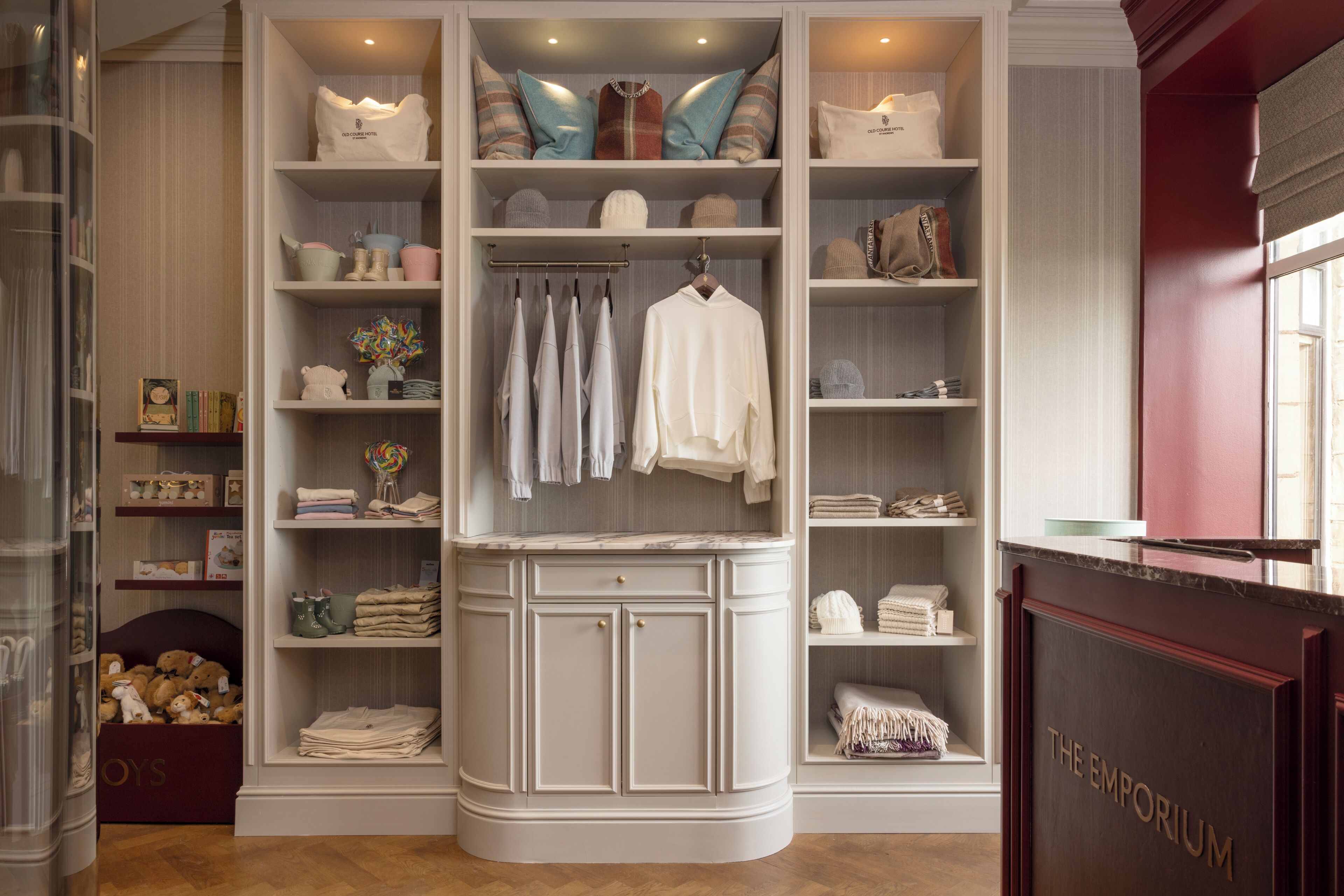 A hotel room with a built-in wardrobe, a marble-topped dressing table, and a view of the outside through a window.