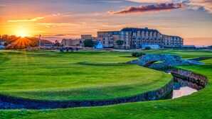 A golf course with a large building in the background.