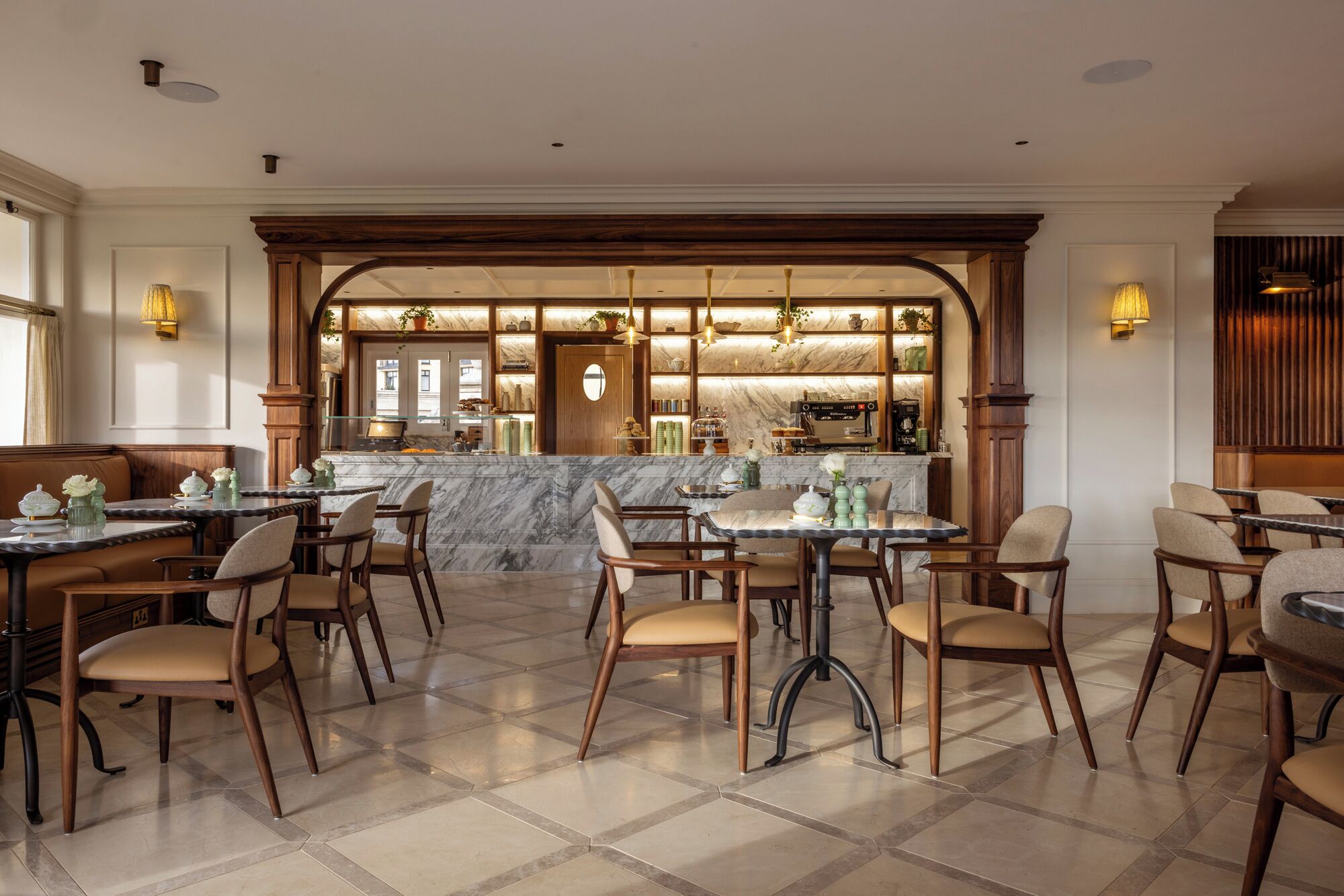 A restaurant with a marble bar, wooden chairs, and a tiled floor.