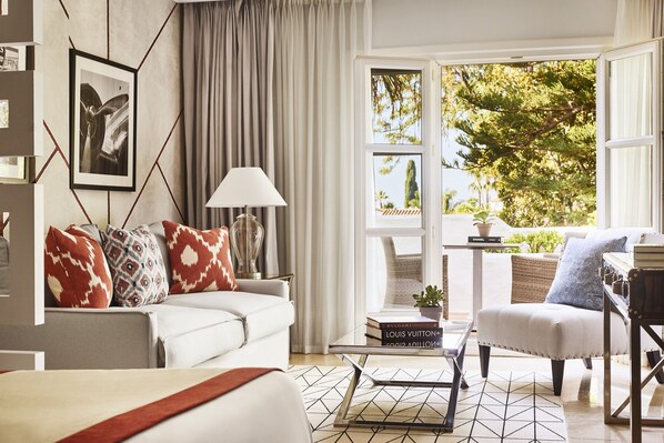 Relax in a comfortable seating area with a sofa and armchairs, and enjoy a view of the outdoors from the large window.