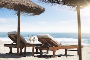 On the beach, black sand, beach towels, 2 beach bars