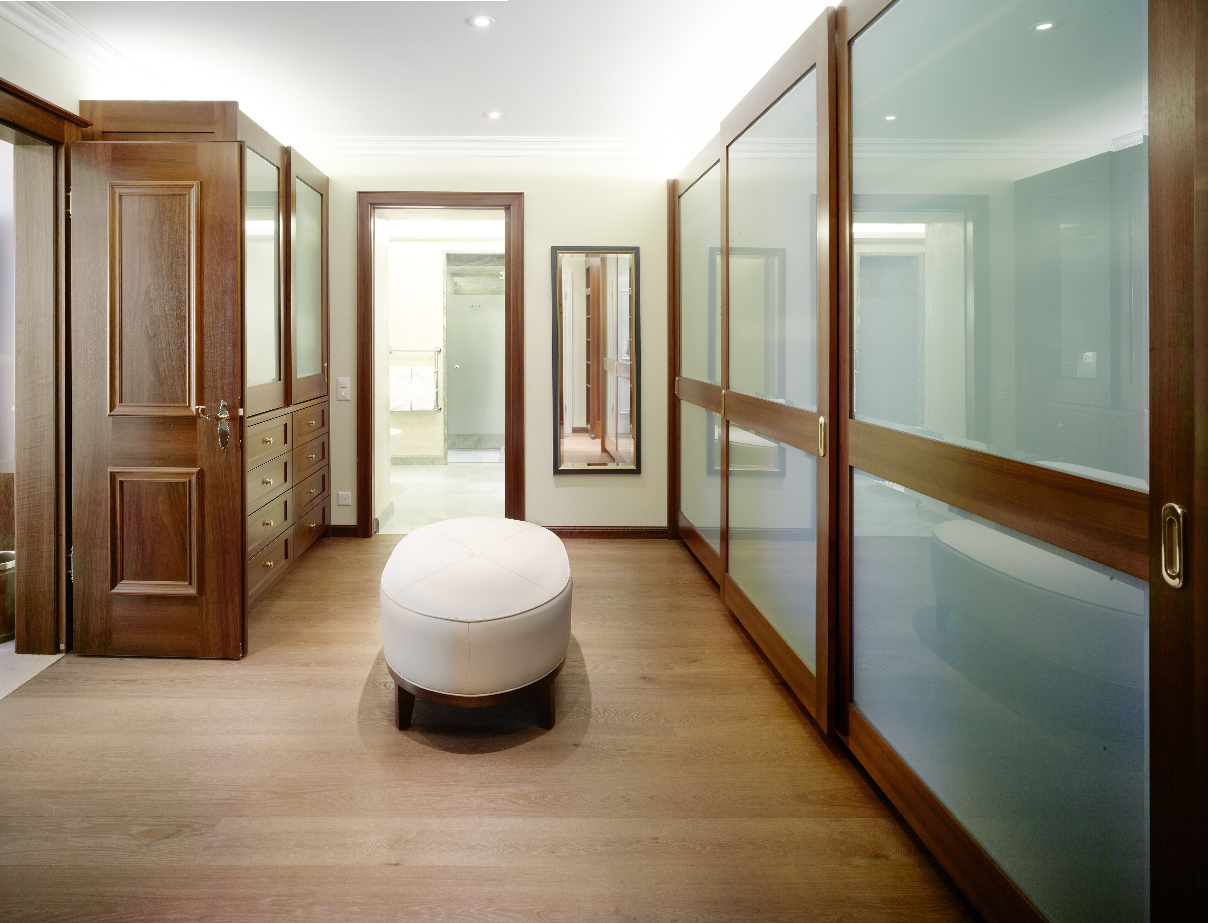 Un dressing spacieux avec des portes en bois et un grand miroir.