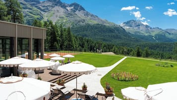 Terraço com área de estar ao ar livre e vista para uma paisagem montanhosa.