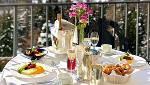 Ein Tisch ist für eine Mahlzeit gedeckt, mit Blick auf die Berge im Hintergrund.