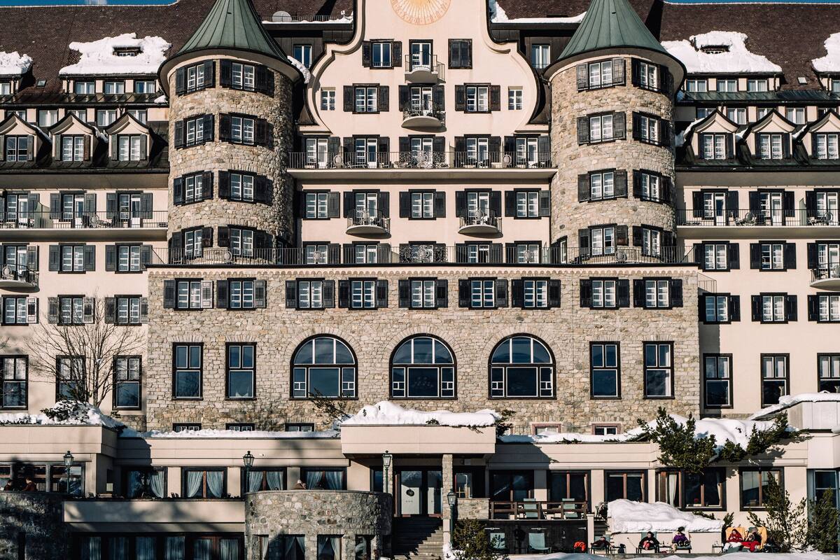 A historic hotel with multiple stories, a central tower, and a snow-covered roof.
