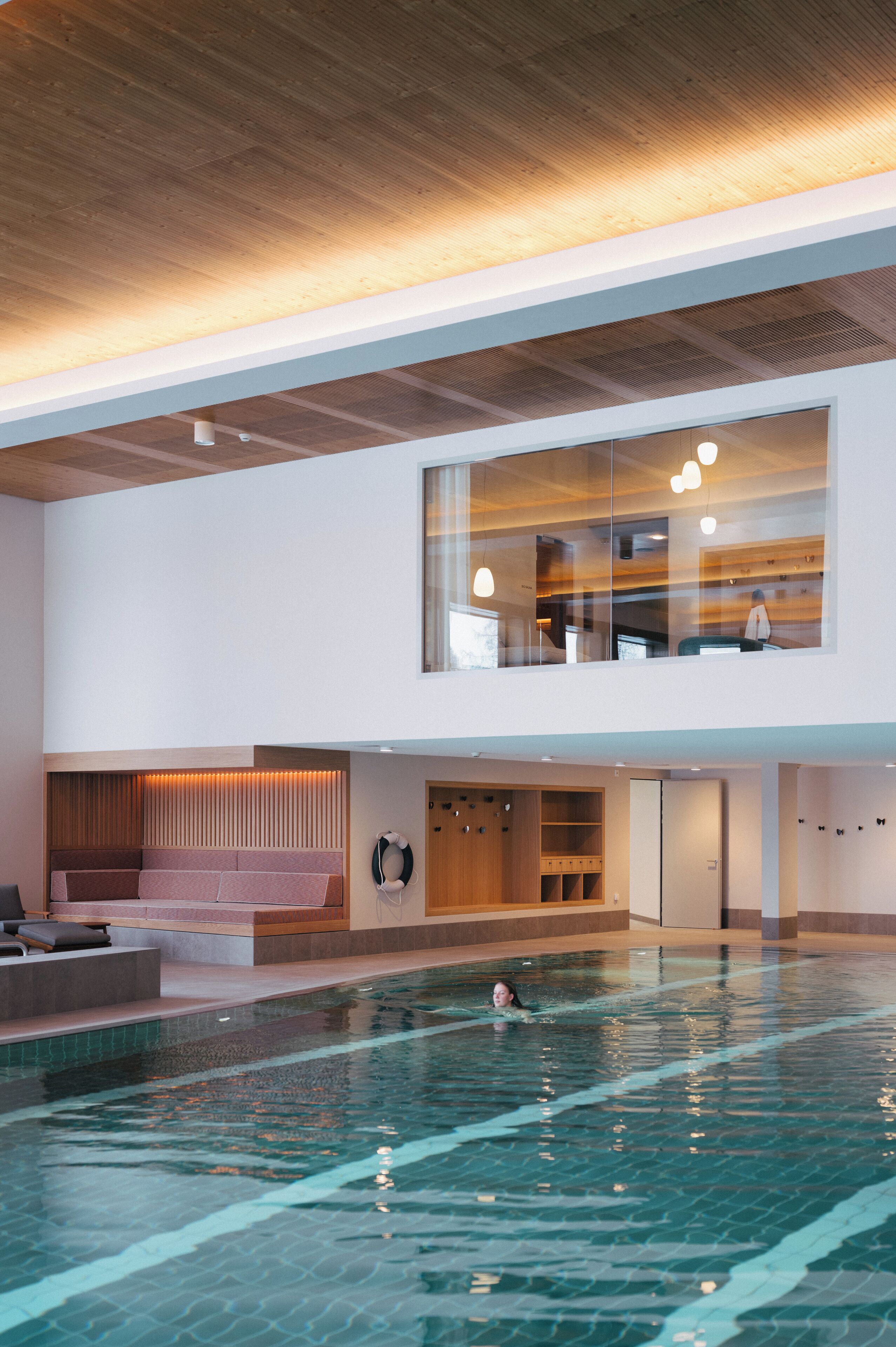 Una piscina interior moderna con una vista despejada del techo y el piso superior.