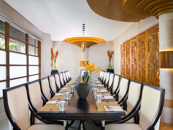 A conference room with a long table, chairs, and a central vase with flowers. - Nusa Dua Beach Hotel and Spa - Handwritten Collection (Nusa Dua)