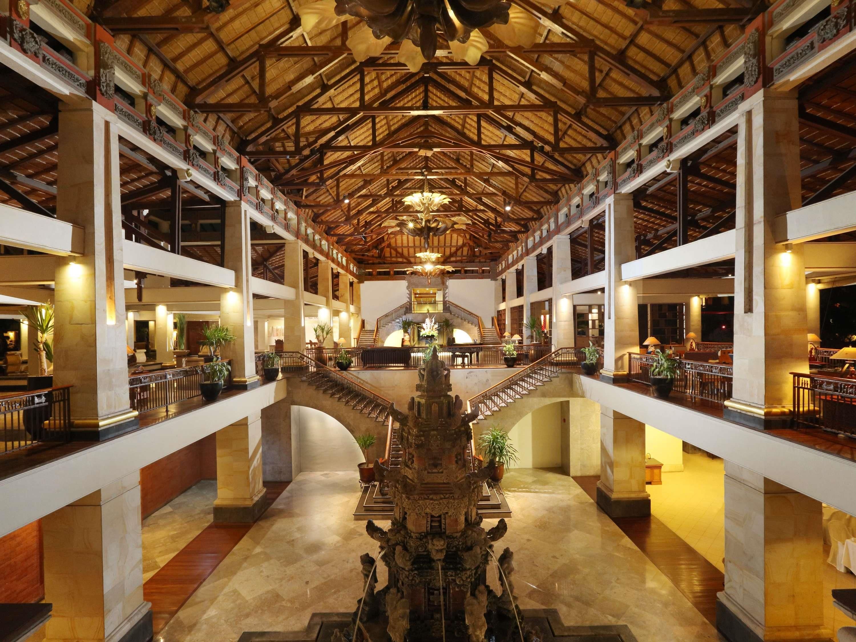 A spacious atrium with a central staircase, high ceilings, and multiple levels.