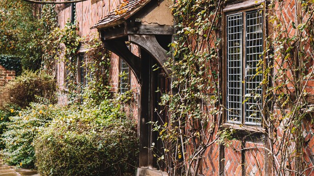 A traditional half-timbered house with a stone pathway leading to the entrance. - Langshott Manor (Horley)