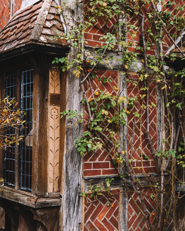 A traditional half-timbered building with a wooden window and brick wall.