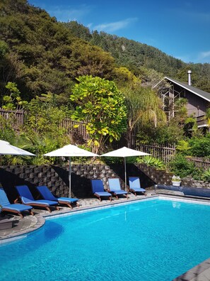 Una piscina al aire libre, tumbonas
