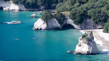 A coastal landscape with rocky formations and clear turquoise waters.