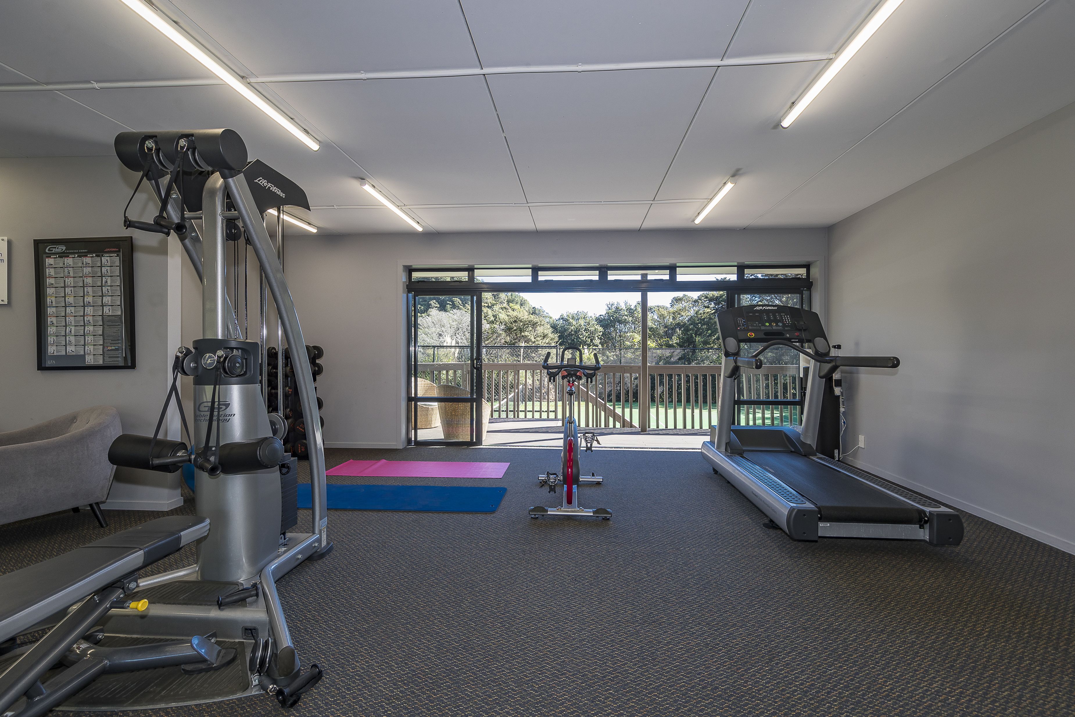 Ein Fitnessraum mit Cardio-Geräten, Laufband und Kraftmaschine.