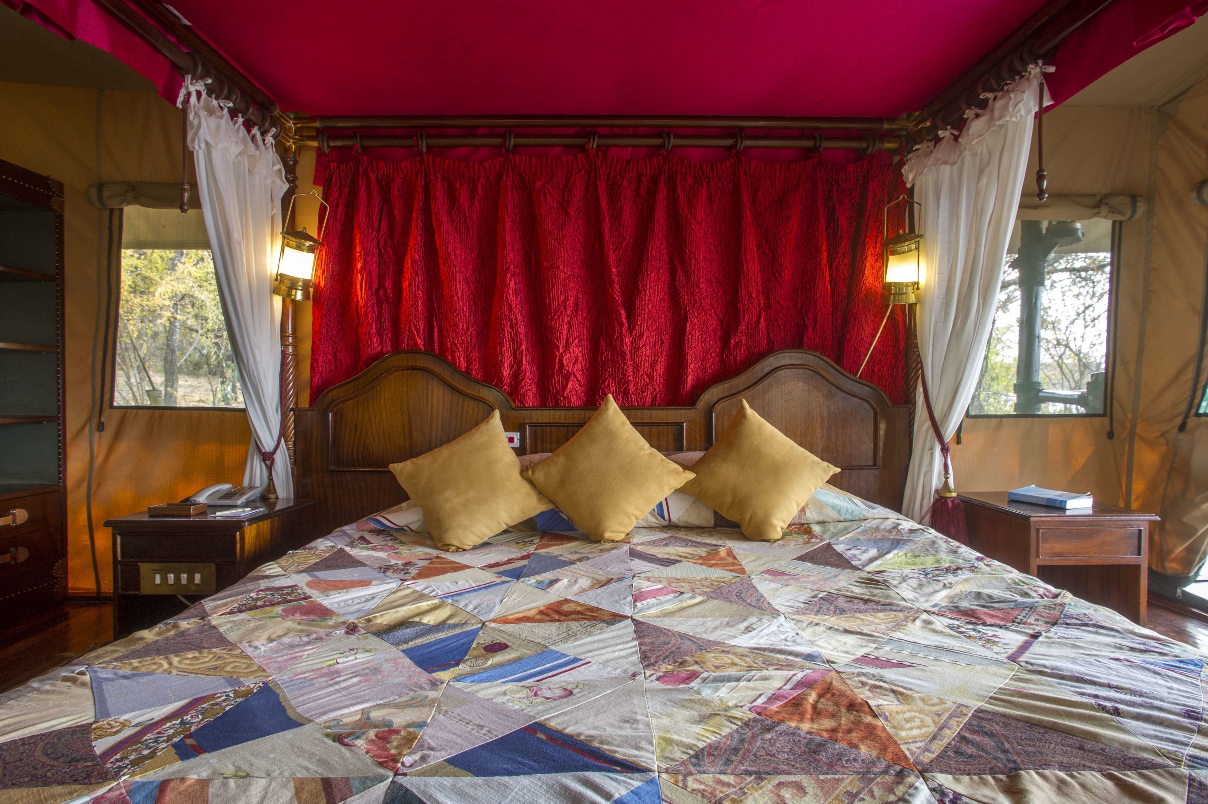 A bed with a quilt, wooden headboard, and three pillows.