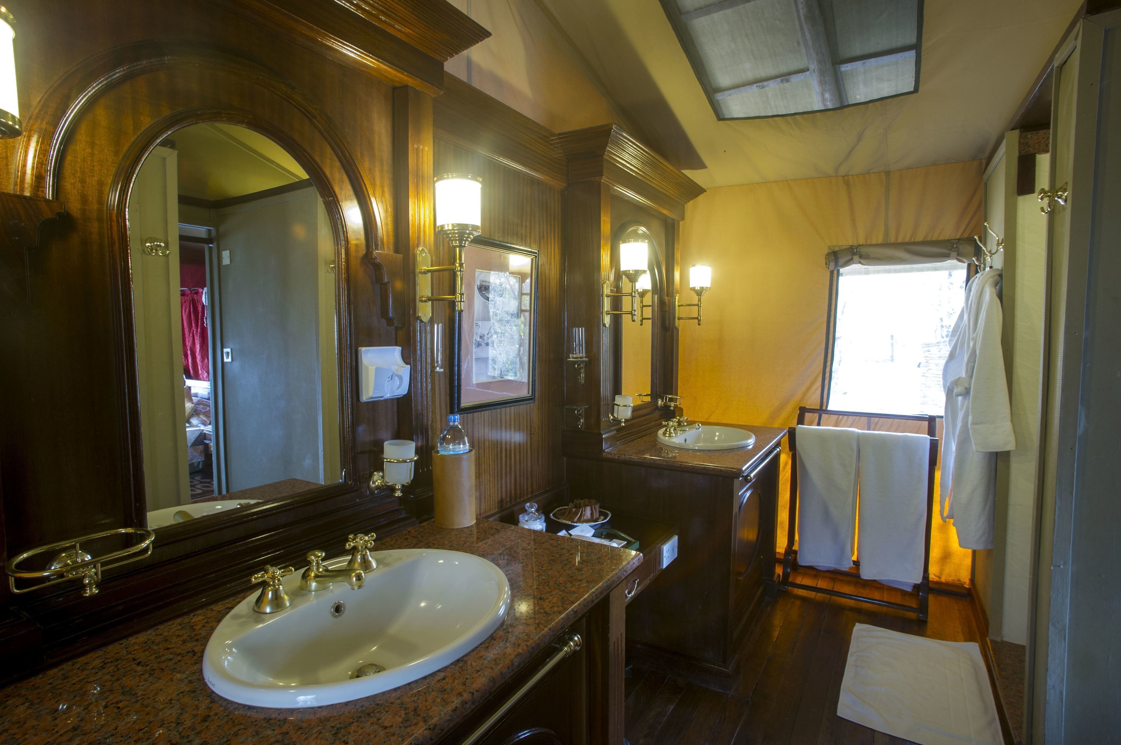 A bathroom with two sinks, a large mirror, and a shower area.