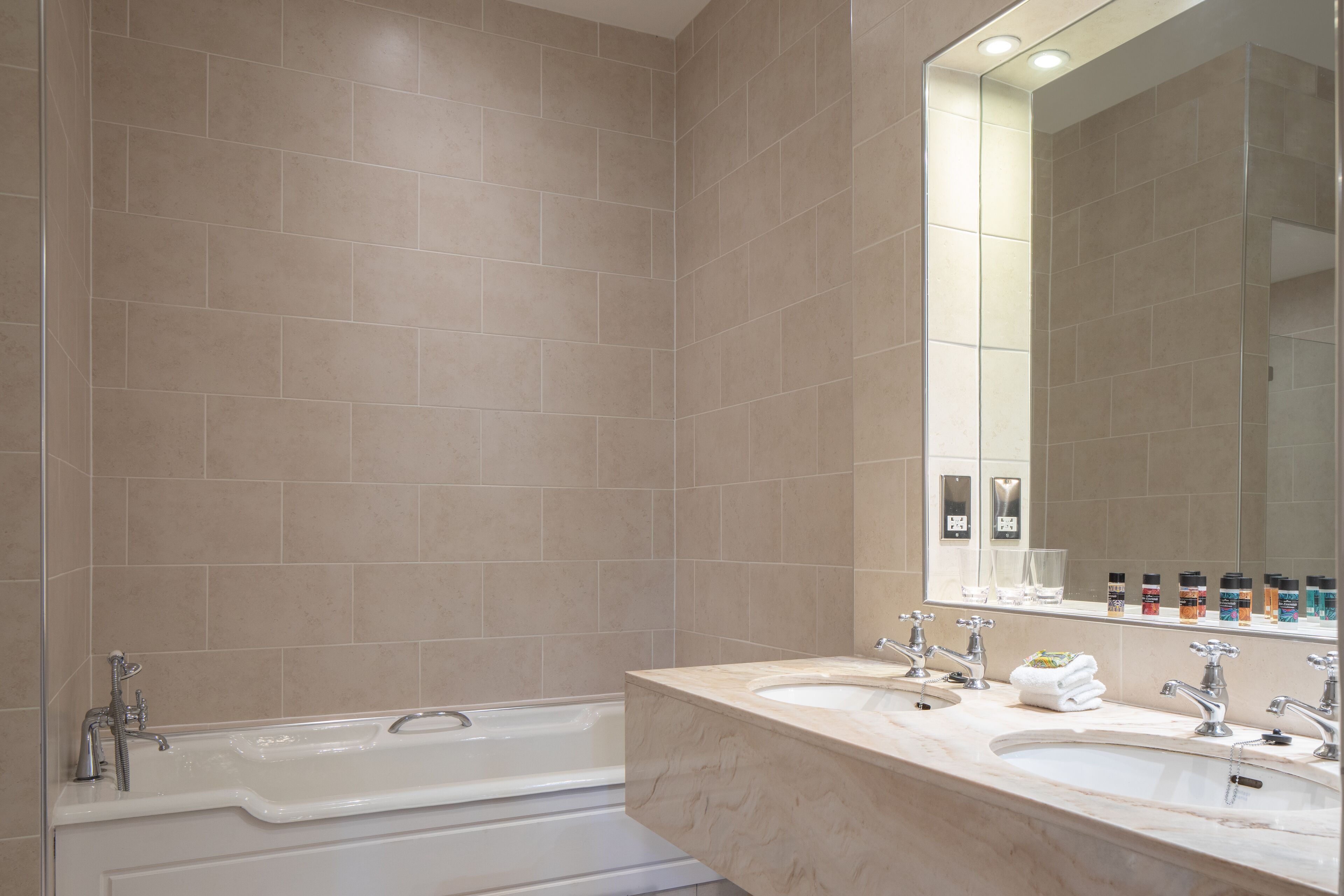 A modern bathroom with a large bathtub, a double sink, and a mirror above the sink.