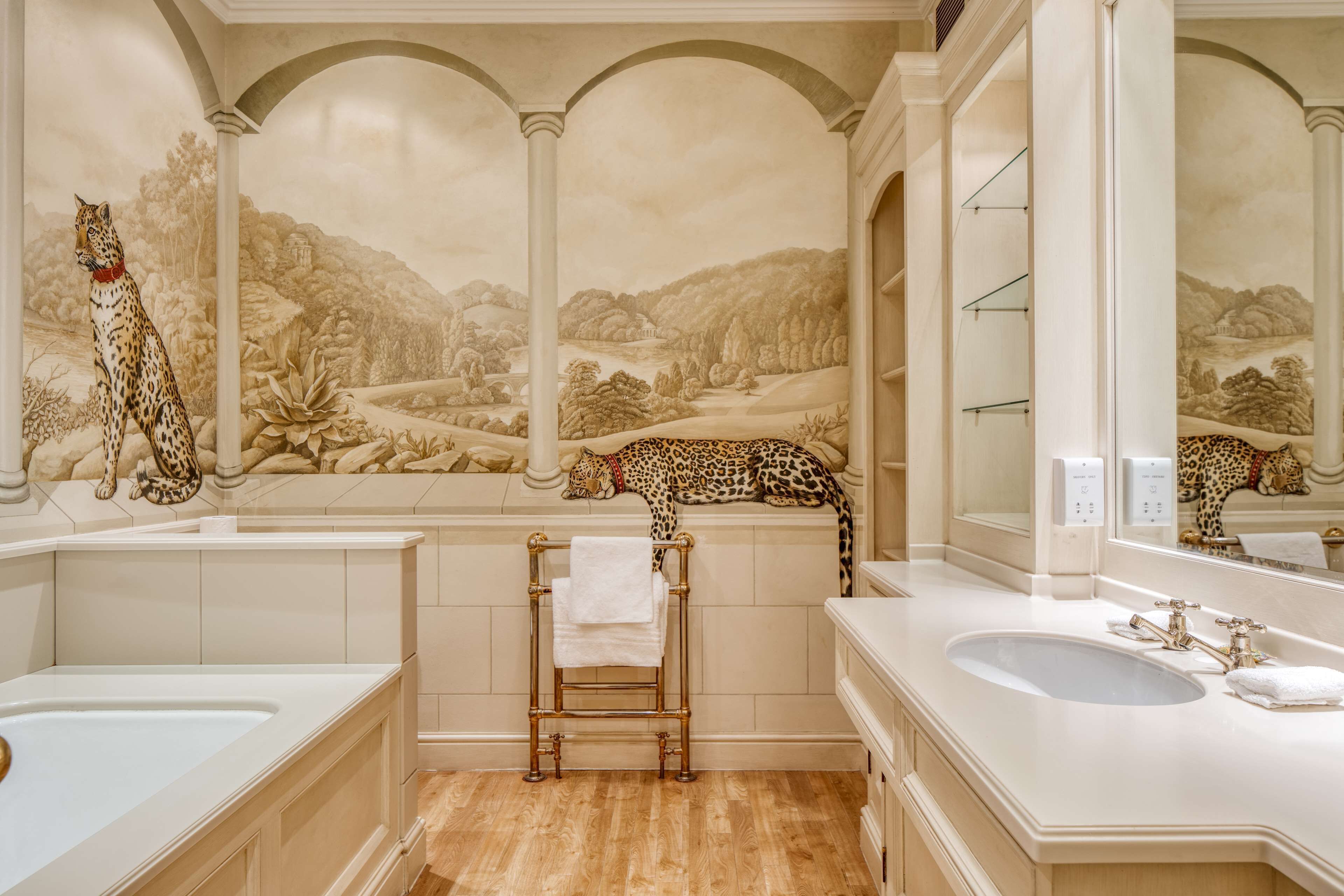 A bathroom with a large mirror, a bathtub, a sink, and a towel rack.