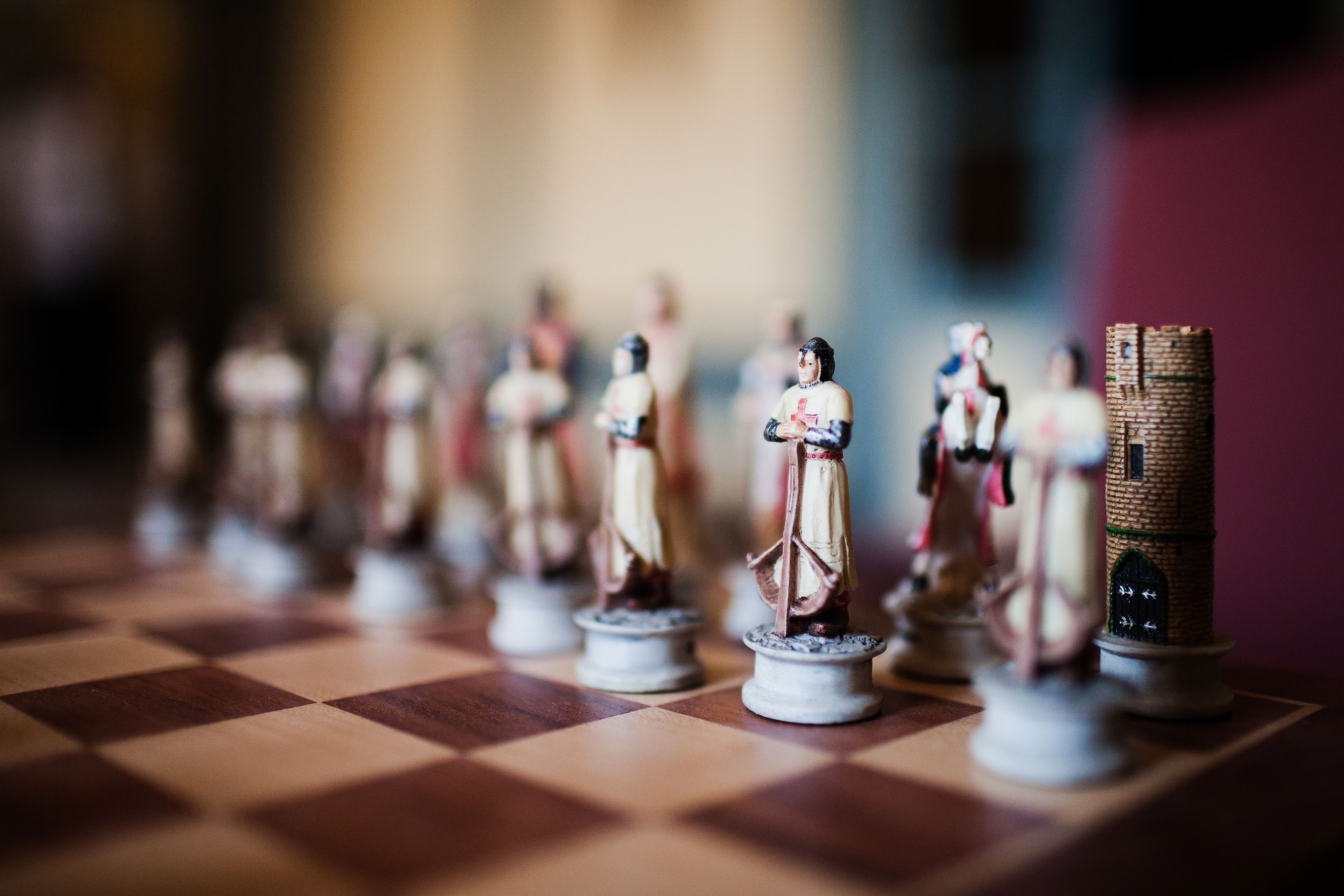 A chessboard with miniature figures and a stack of coins.