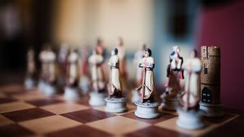 A chessboard with miniature figures and a stack of coins.